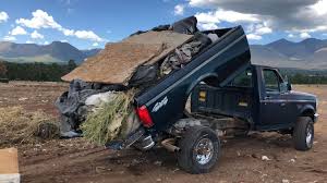 Pickup truck with dump-style bed used for hauling cleanup debris
